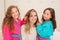 Close up of two litle girls playing with the hair of their mom, while curly girls is wearing a pink bathrope and