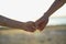 Close up of two Lovers Joining Hands. Detail Silhouette of Man and Woman holding hands over the Sunset Lake Background. Couple Tru