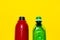 Close-up of two opened water bottles. Reusable steel thermo bottle of red color and disposable plastic bottle of green. 