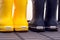 Close-up of two pair of Crocs rubber boots standing in hallway near door