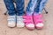 Close-up of two pairs of children\'s feet dressed in jeans and sneakers