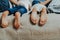 Close up of two pairs of kids feet in bed