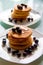 Close up of two plates with towers of tasteful cinnamon pancakes topped with fresh blueberries and maple syrup, sweet and tasty
