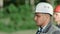 Close-up two professional metal worker in helmet and glasses walking outdoor at production plant