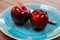 Close up of  two red dotted shiny isolated dessert apples on blue china dish with knife