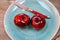 Close up of  two red dotted shiny isolated dessert apples on blue china dish with knife