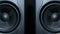 Close-up of two round audio sub-woofers vibrating