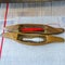 Close-up two shuttles and spools with red and white strings for the loom on a homespun textile