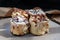 Close up of Two Soft Chocolate Buns topped with rich cream cheese frosting and Two Caramel Pecanbon topped with decadent caramel