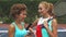 Close up of two tennis girls discussing while sharing a smartphone