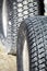 Close up of two tyres or tires on sandy mud, showing tread detail, one in focus and one in out of focus background