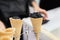 Close-up of two waffle cones, horns with balls of trendy black ice cream and hand of the seller. Delicious cooling