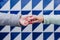 close up of two women holding hands against blue and white tiles. friendship or lgtbi concept