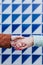 close up of two women holding hands against blue and white tiles. friendship or lgtbi concept