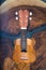 Close-up of a ukulele head - small light brown instrument on beautiful wooden table