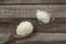 Close-up uncooked dry Thai jasmine rice are overflow from wooden ladle on wooden floor, angle of view flat lay and top down view.