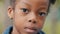 Close-up unemotional child face african american little girl pensive looking at camera sad lonely no emotion kid serious