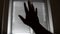 Close-up unfocused silhouette of a man`s hand reaching for the light.