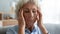 Close up unhappy older woman touching temples, suffering from headache