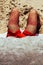 Close up of unidentifiable man`s sunburnt legs on beach wearing red shots