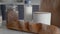 Close up of unpacked shopping bag with bread, buckwheat, oatmeal, milk, vegetables on wooden table in kitchen. Zero