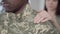 Close-up of unrecognizable African American man in military camouflage with blurred Caucasian woman putting hand on