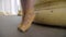 Close-up of unrecognizable ballerina in yellow pointes standing up on tiptoes. Slim female Caucasian feet in pointe