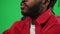 Close-up unrecognizable bearded African American man talking watching football match on green screen. Concentrated sport