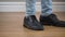 Close-up of unrecognizable Caucasian man`s feet running from the right, turning to both sides, and walking away to the