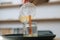 Close-up of unrecognizable female artisan pouring melted wax into tranparent glass jar with wick at home.