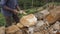 Close up of unrecognizable indian man cutting a block of granite with hammer in botanical garden. Adult human hitting