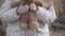 Close-up of unrecognizable little girl squeezing teddy bear in hands. Frightened Caucasian child lost outdoors. Social