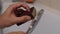 Close-up unrecognizable male hands cleaning calcified shower head in bathroom over bathtub using sponge and soapy