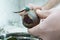 Close-up of unrecognizable man wearing peeling beet with peeler knife over bowl full of peelings, standing in kitchen.