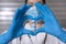 Close up of unrecognizable nurse with medical mask and protective gloves. She is forming a heart with her hands showing a glass