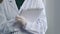 Close-up unrecognizable woman doctor nurse unknown practitioner in uniform white coat wears latex gloves holds folder