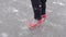Close up of unrecognizable woman in high-heeled shoes glides on ice. Crazy female on outdoor ice rink in winter time.