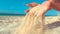 CLOSE UP: Unrecognizable woman lets breeze sweep away the sand from her hands.