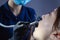 Close-up, from an unusual angle, view, a dentist using dental equipment treats a patient a girl with a tooth and oral cavity