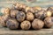 Close-up of unwashed potato tubers on a wooden background.