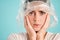 Close up upset girl with plastic bag on head scaredly looking in camera over colorful background isolated