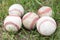 Close-up used baseballs on green grass field, sport concept