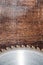 Close-up used blade circular saw on the background of the wooden table. Workshop for the production of wooden products
