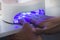 Close up of a uv led lamp with a female hand inside fixing the gel nail polish . Woman puts a hand under a UV lamp for varnish