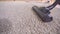 Close up of a vacuum cleaner vacuuming the carpet