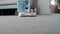 Close up of vacuum cleaner vacuuming carpet in modern apartment. Young woman to keep house neat at home in living room