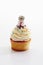 Close up of vanilla buttercream cupcake with cat figurine agains