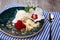 Close-up of vanilla ice cream with raspberries. A blue bowl with ice cream and a spoon on a fabric. Sweet desserts for gourmets.