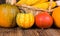 Close Up of various pumpkins in front of a basket with corn cops