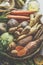 Close up of various raw organic root vegetables: Parsnip, sweet potato, carrots, kohlrabi and jerusalem artichoke on plaited tray